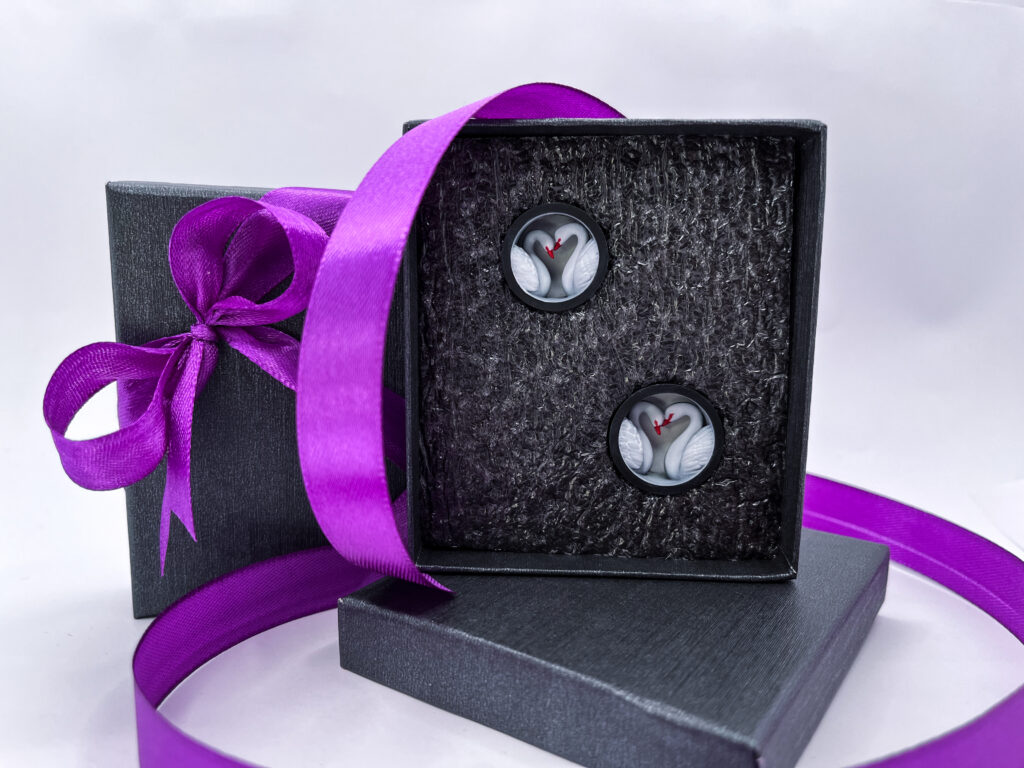 cruxed handmade plugs two swans in a gift box with a purple ribbon