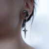 star-shaped silver earring inside woman's ear tunnel 12mm